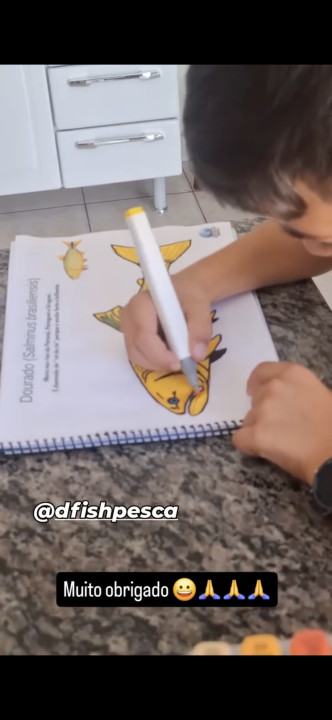 Criança colorindo o peixe Dourado